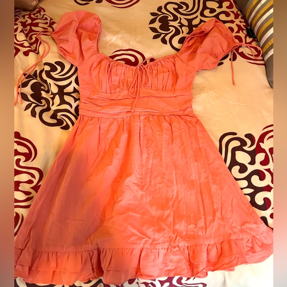 This is a coral dress with puffy sleeves